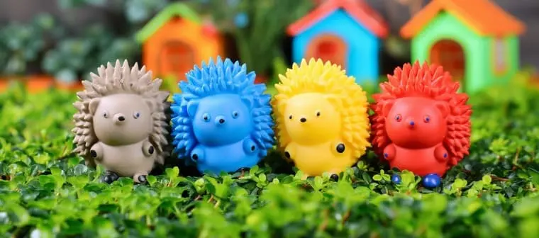 Brinquedos de vinil em formato de porco-espinho, nas cores cinza, azul, amarelo e vermelho